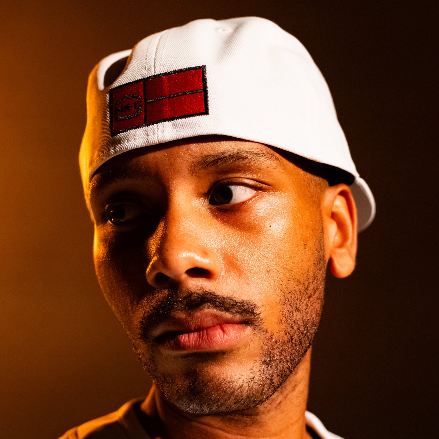 The hat being worn backwards by a model; Red state flag on back of hat