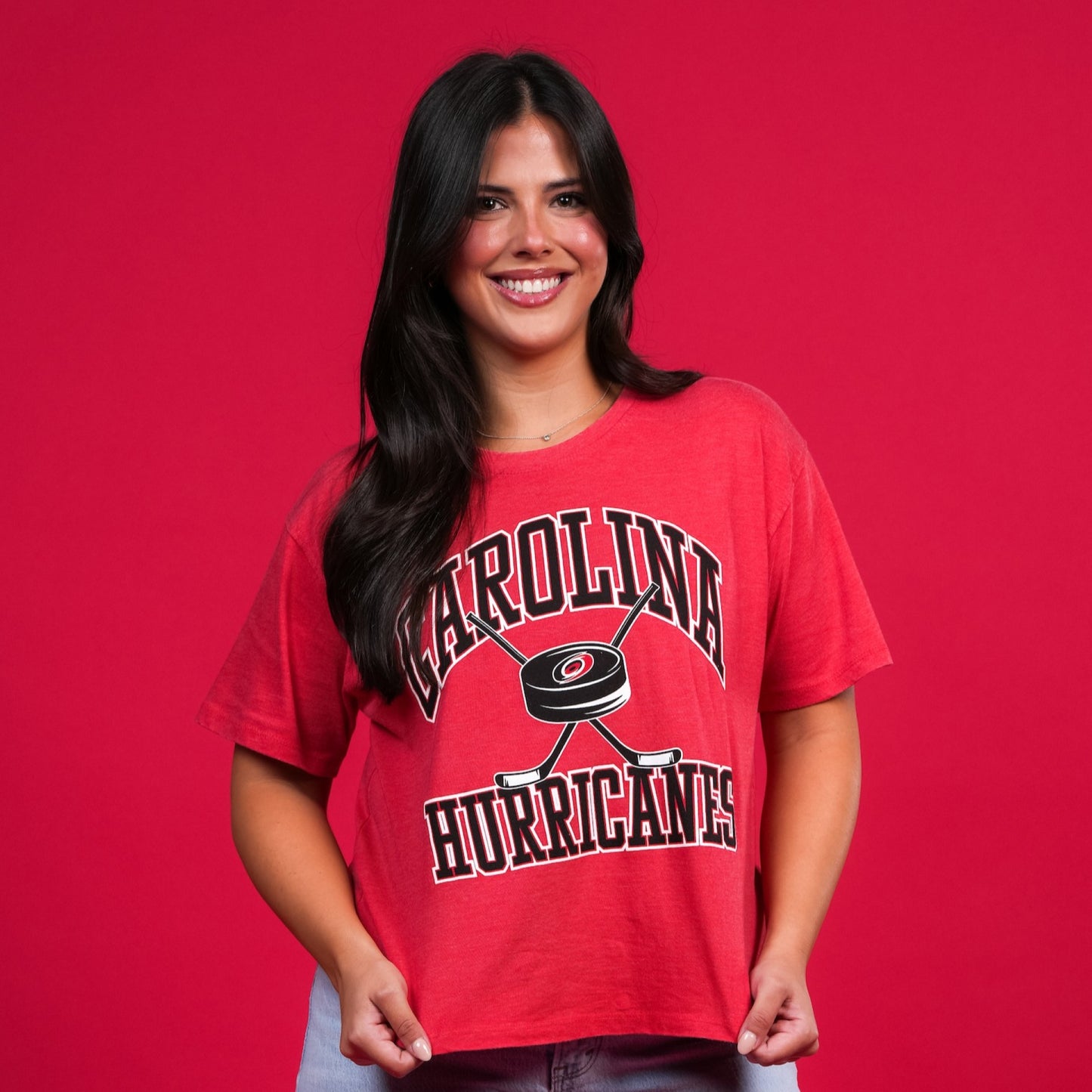 The shirt being worn by a model in front of a red backdrop