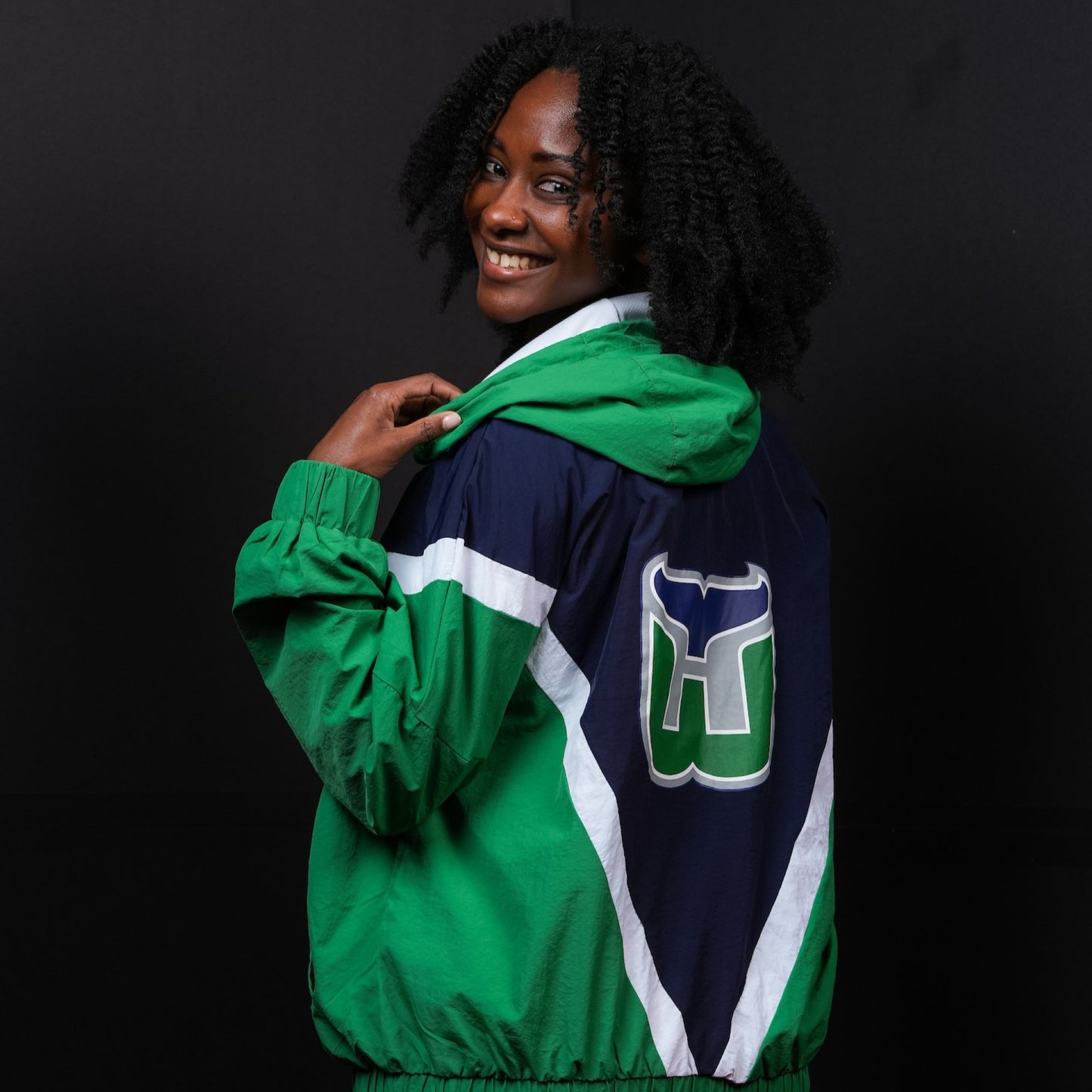 Back: Green and blue windbreaker with white trim, Whalers tail logo on back