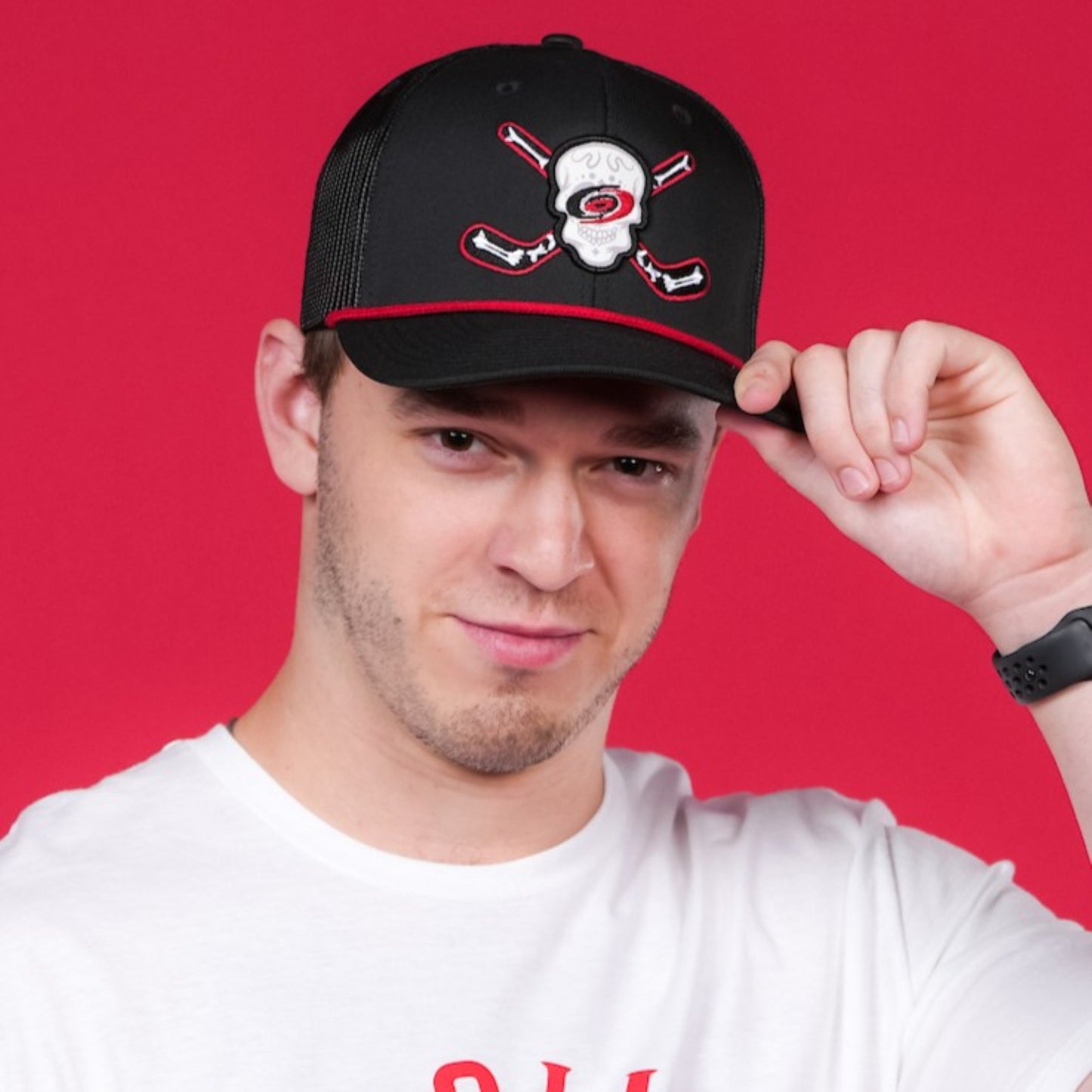 The hat being worn by a model in front of a red backdrop