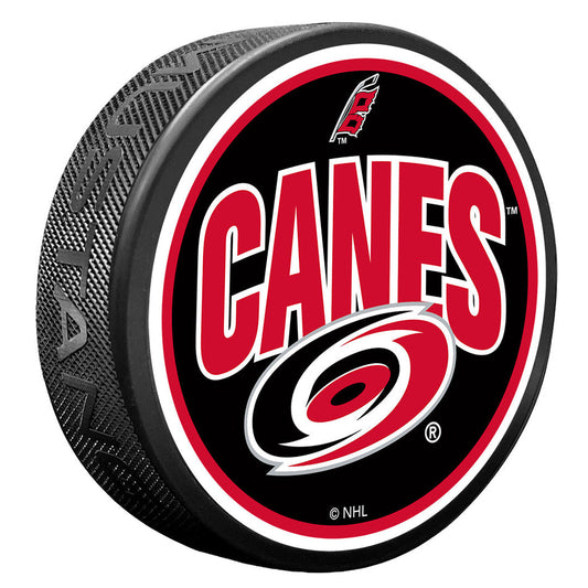 Puck with black face, red and white trim, says "CANES" with primary and flags logos