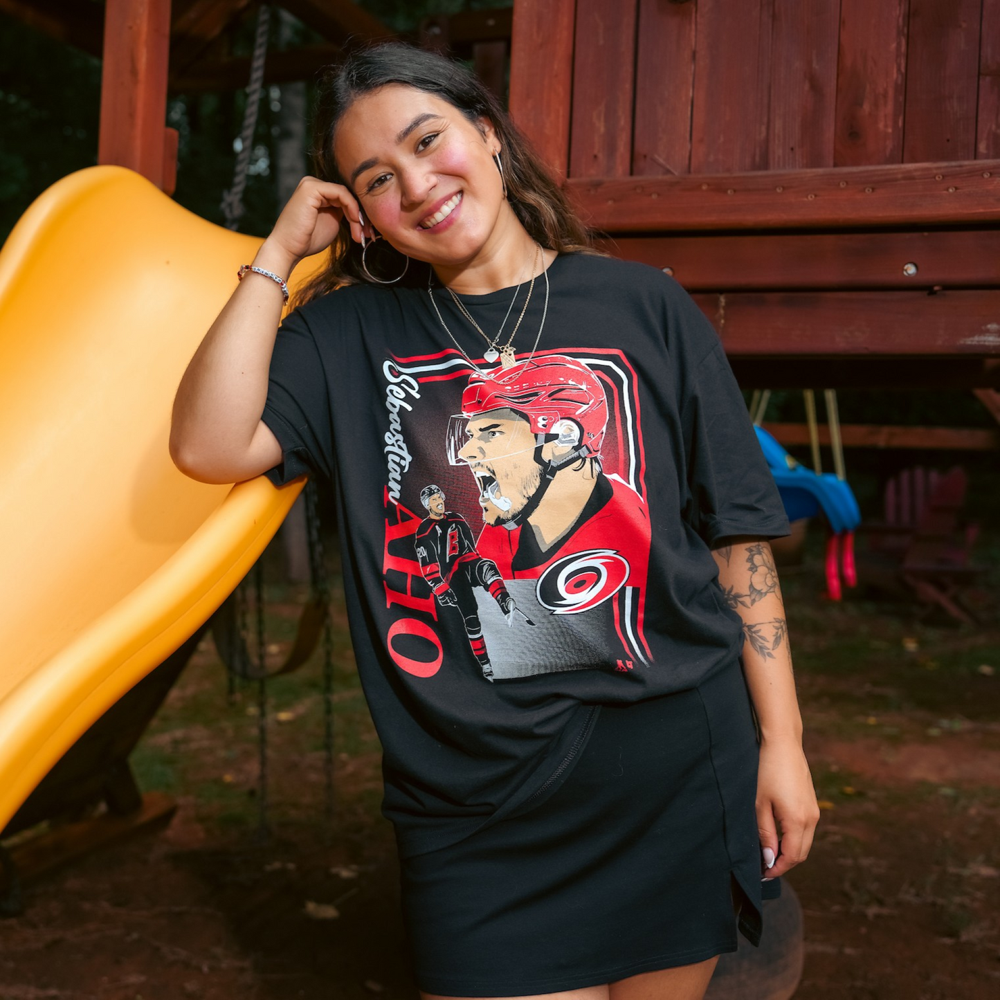 The t-shirt being worn by a model outside next to a slide