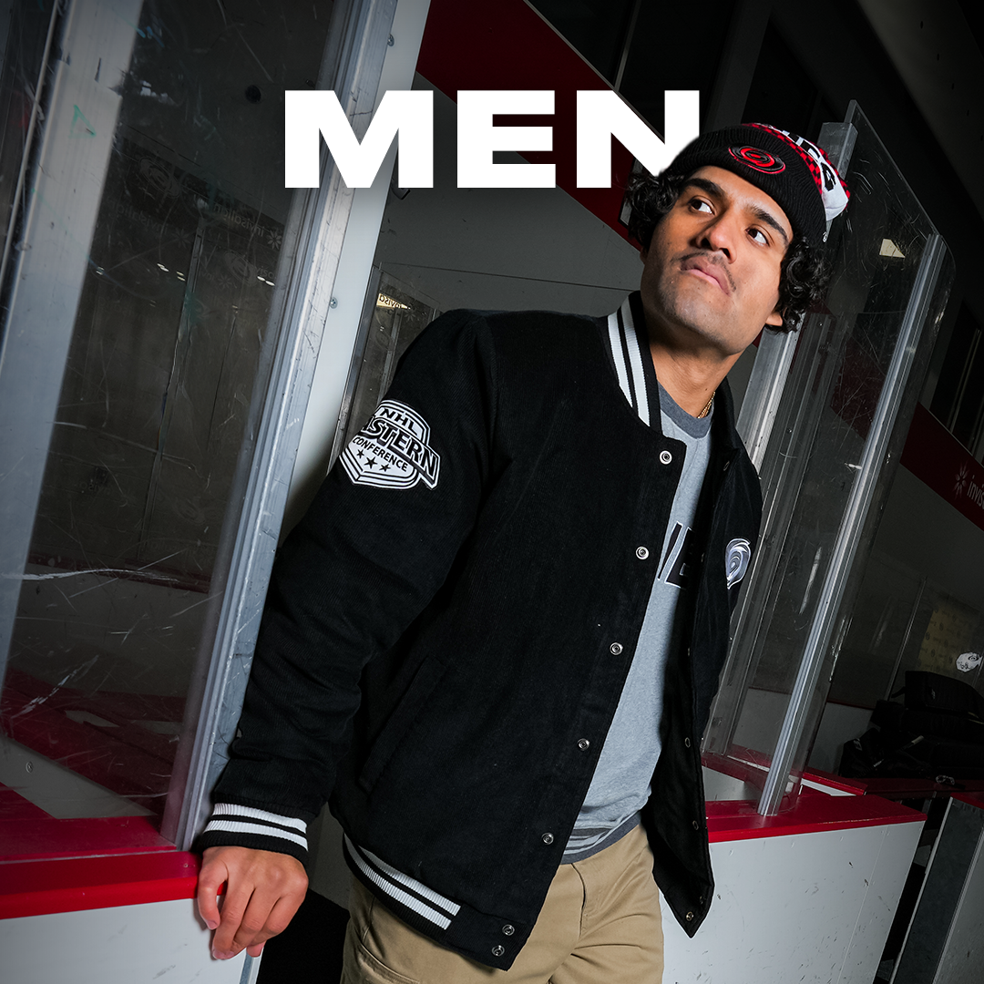 "MEN" in white text behind a model wearing Hurricanes merch in a penalty box