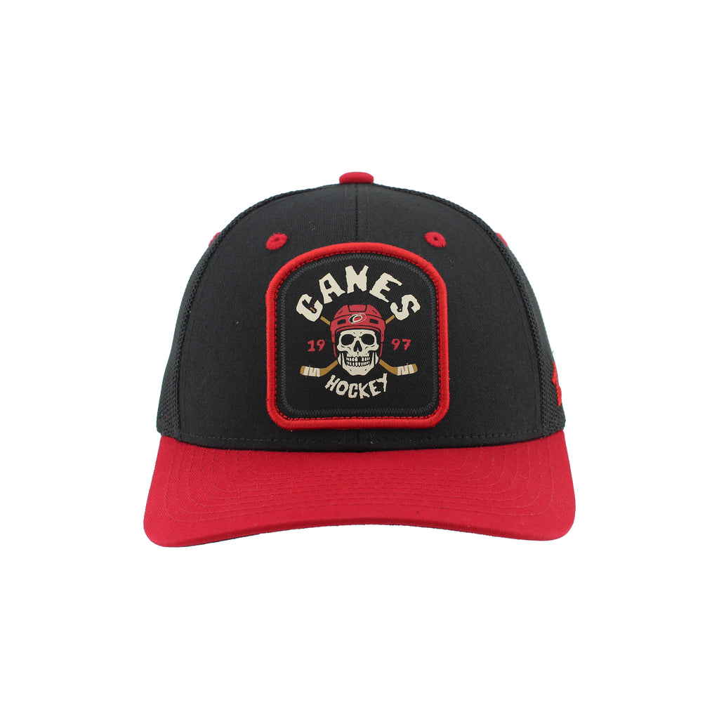 Front: Black tombstone-shaped patch with red trim,  "CANES HOHCKEY 1997" in white/red around skull wearing helmet with cross sticks