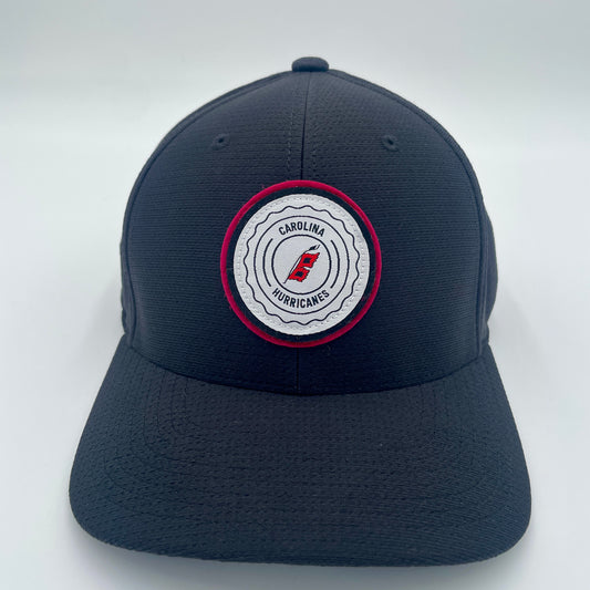 Front: Black hat with white and red circular patch, says Carolina Hurricanes with Flags logo