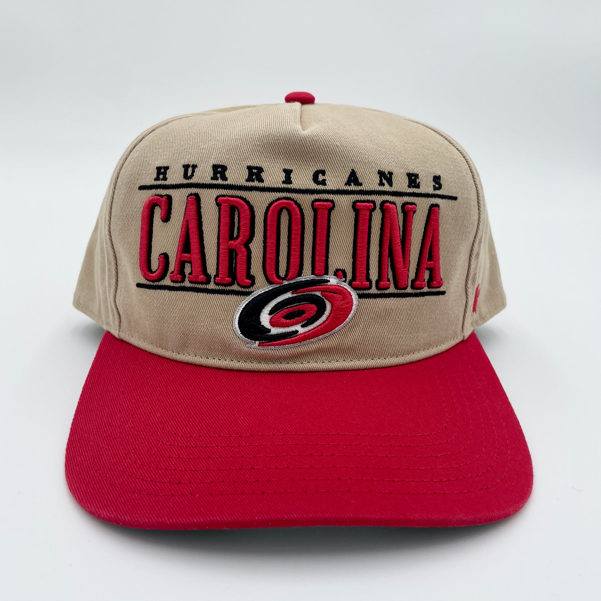 Front: Biege hat with red brim, graphic says Carolina Hurricanes in red/black with primary logo