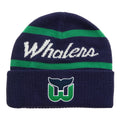 Front: Navy blue cuffed beanie, "Whalers" in cursive white with green stripes above/below, Tail logo on cuff