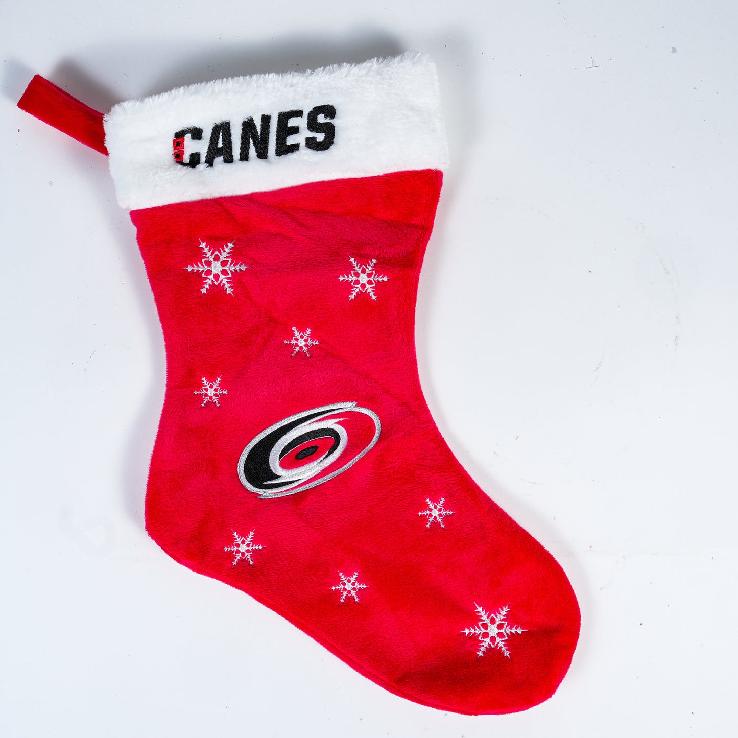 Stocking with CANES wordmark at top and Hurricanes logo with snowflakes on red portion 