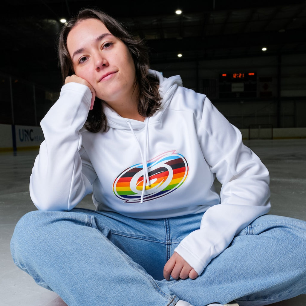 The hoodie being worn by a model who is sitting on an ice rink