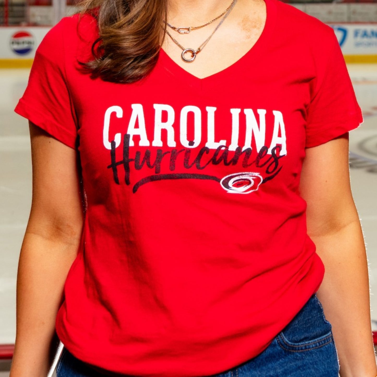 Red v-neck tee; "CAROLINA" in white, "Hurricanes" in script in black with Primary logo