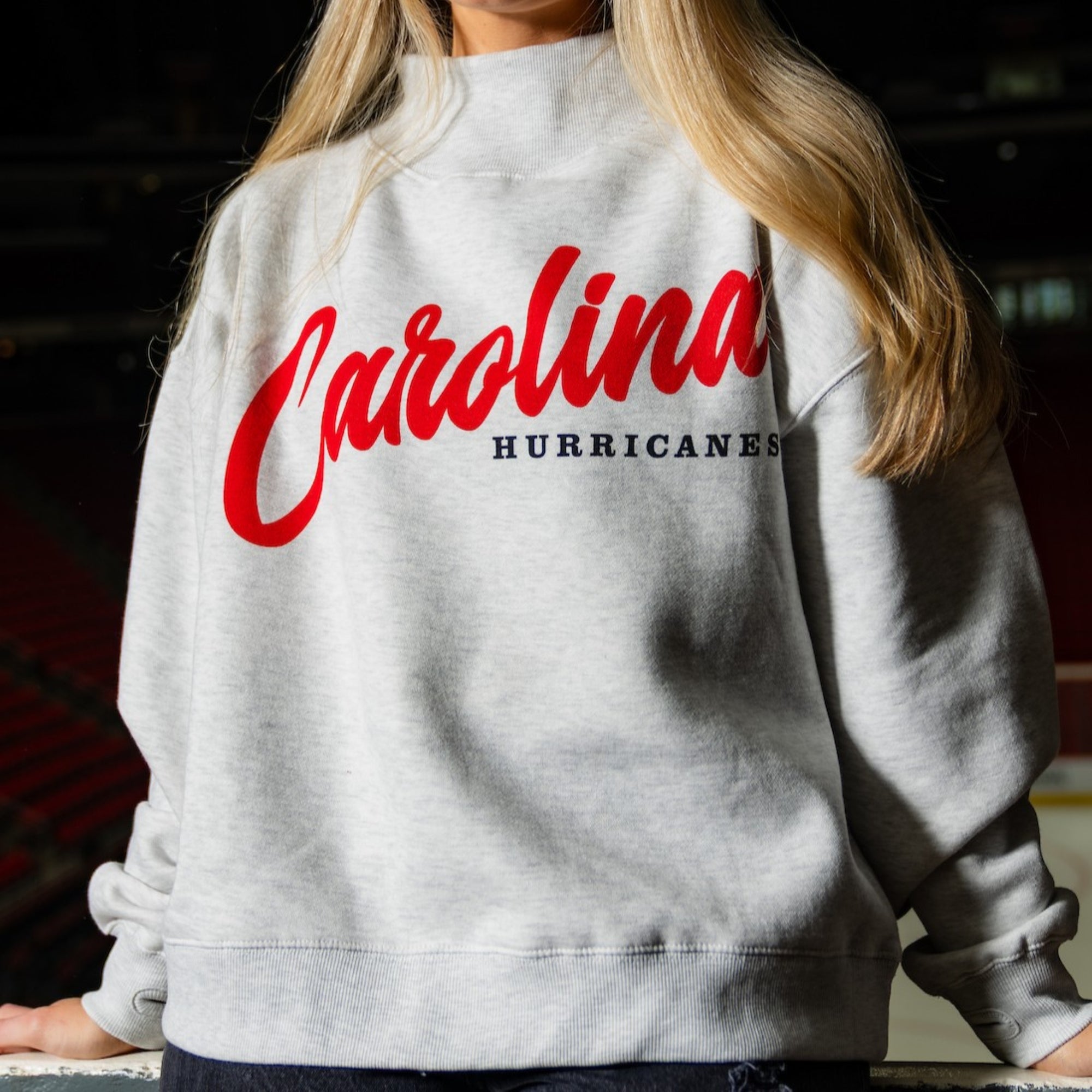 Gray sweater with turtleneck; :"CAROLINA" in cursive in red, "HURRICANES" in black