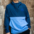 Front: Half-zip jacket, dark blue upper-half, light blue lower-half, blue Whalers Tail logo left chest