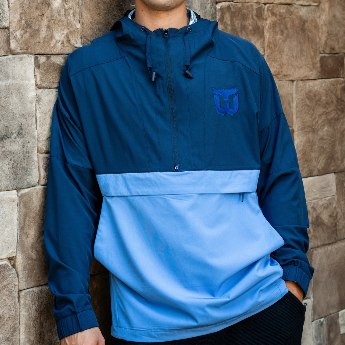 Front: Half-zip jacket, dark blue upper-half, light blue lower-half, blue Whalers Tail logo left chest