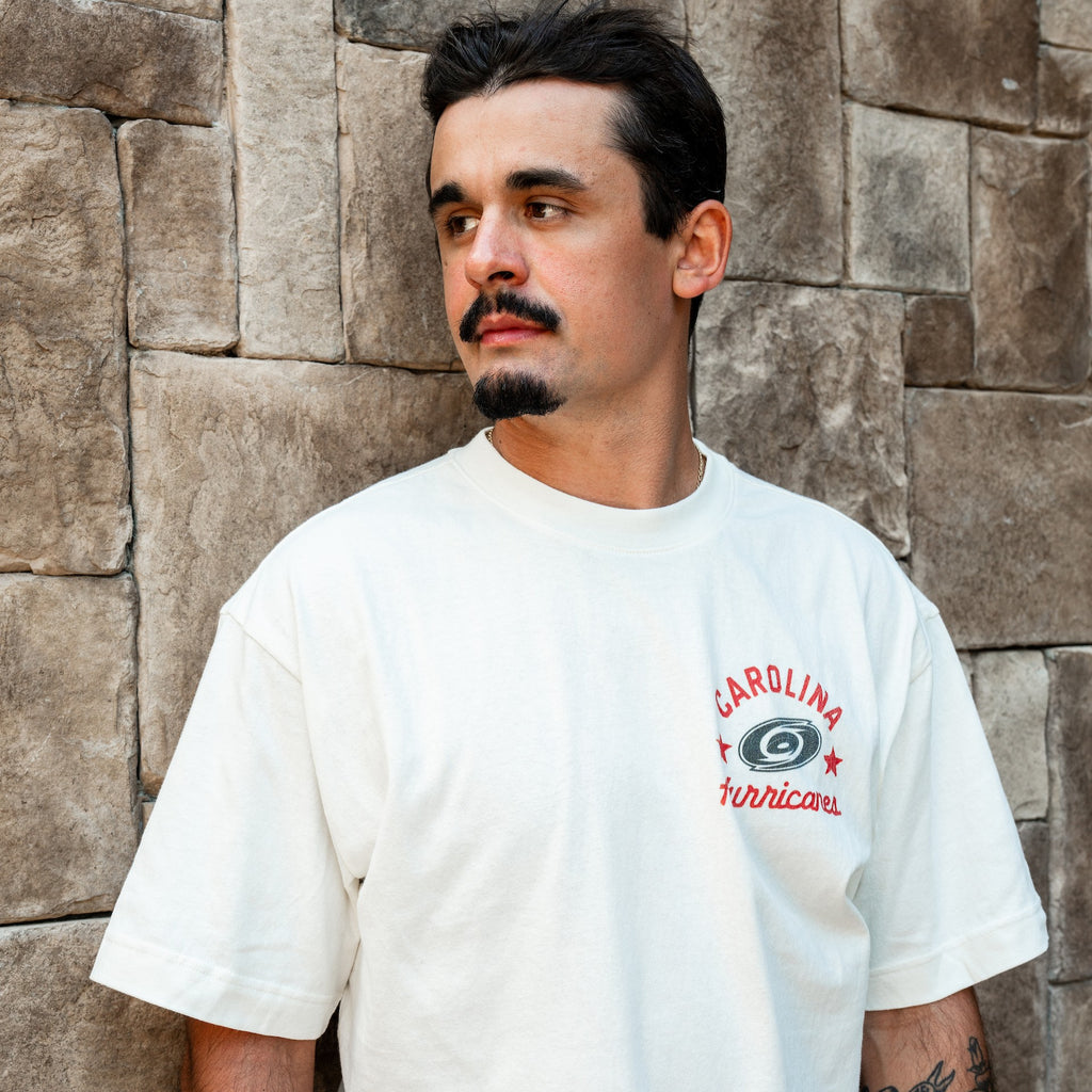The tee being worn by Hurricanes forward Seth Jarvis outdoors
