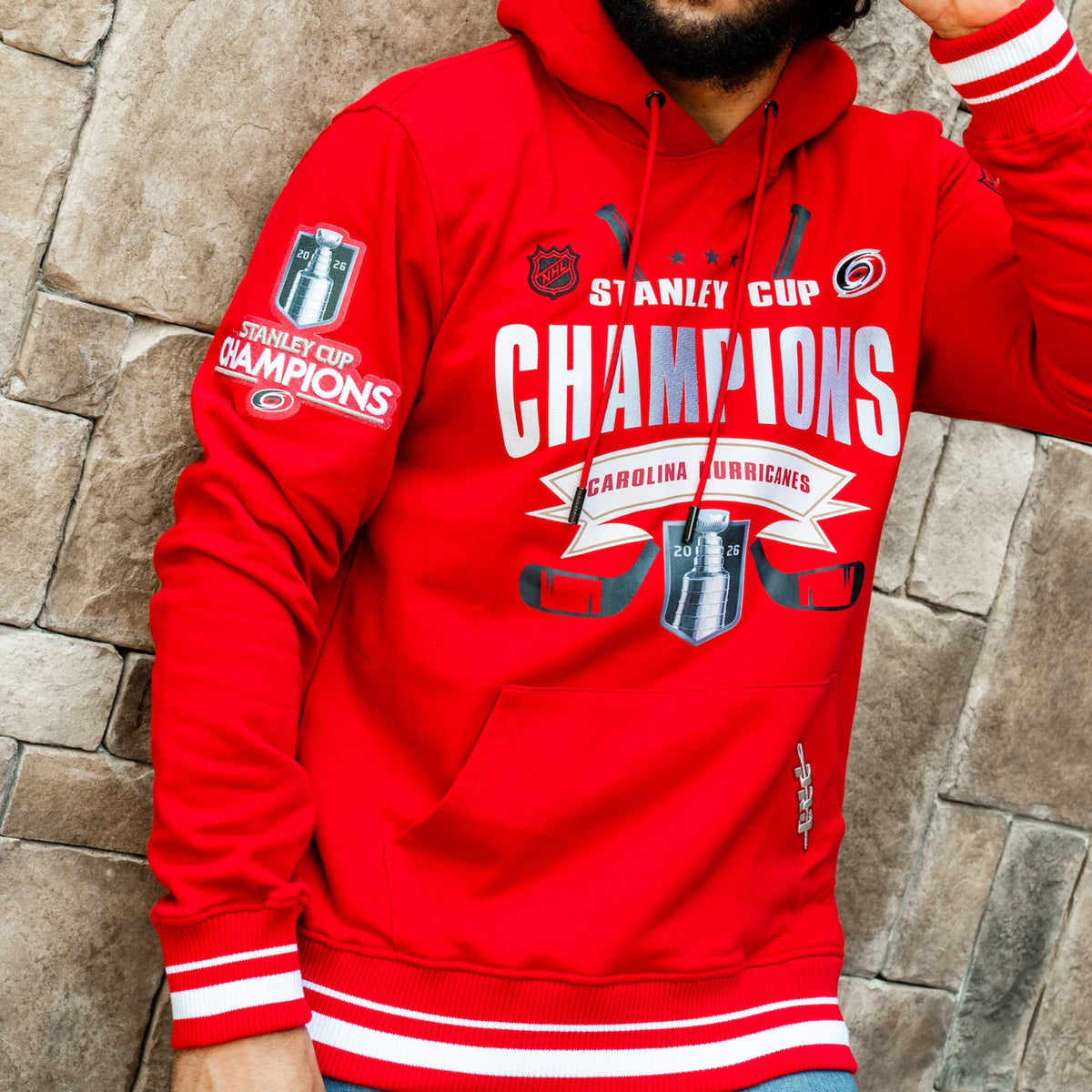 Front: Red hoodie, white striping at waist/wrists, Stanley Cup Champions artwork on front