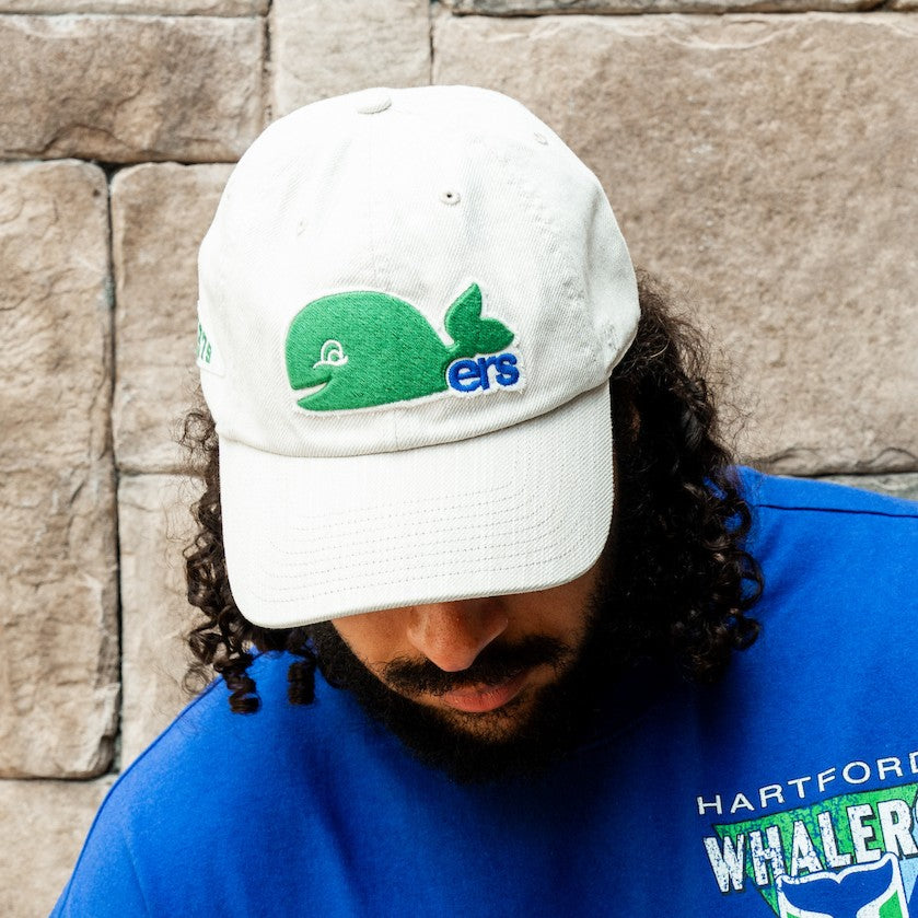 The hat being worn by Hurricanes defenseman Jalen Chatfield in front of a wall