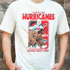 Front: White tee, "CAROLINA HURRICANES NATIONAL HOCKEY LEAGUE" in red around rectangular artwork of vintage goalie