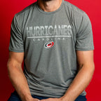 Gray tee, "HURRICANES" with white line, "CAROLINA" beneath all in white with Primary logo beneath