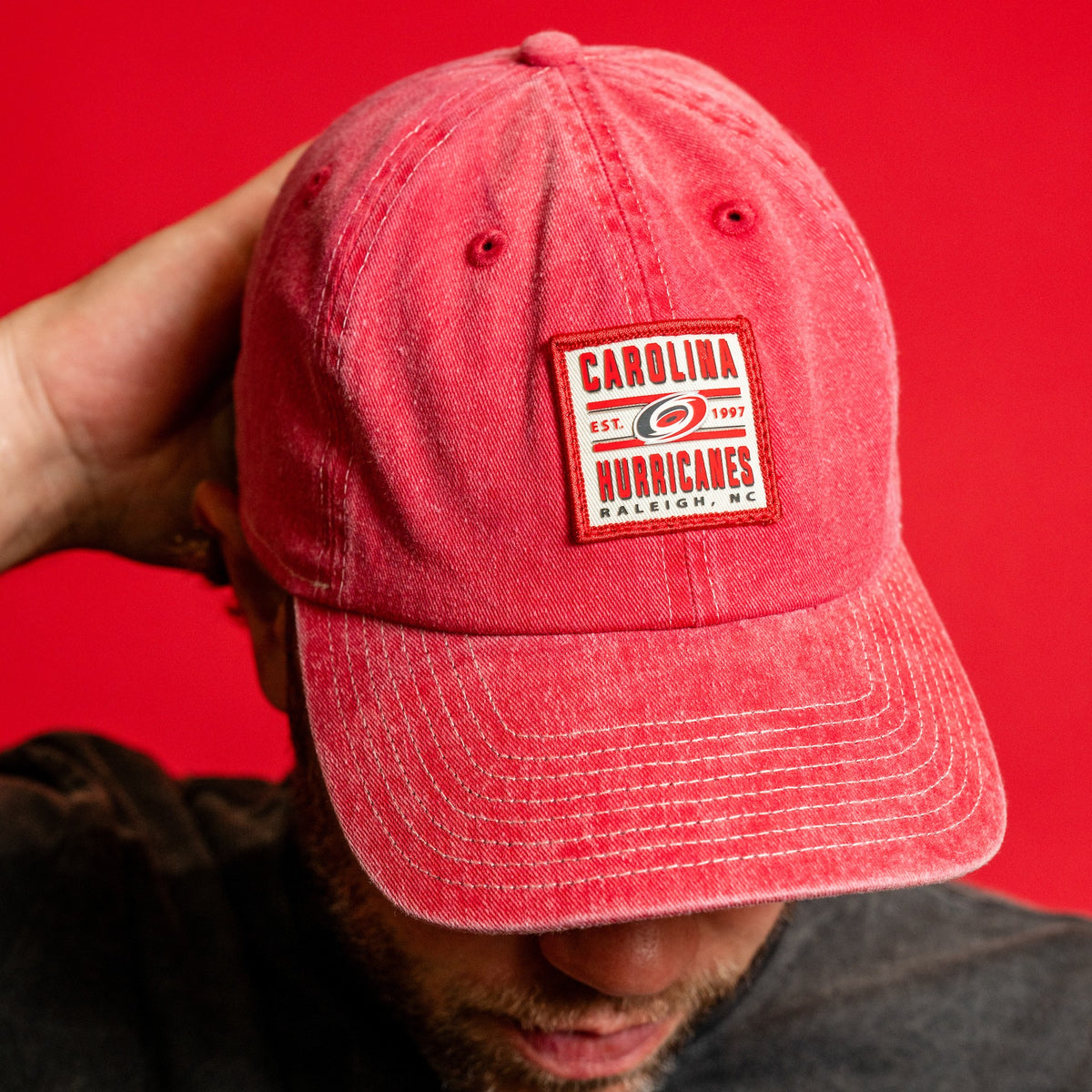 Red hat, red/white square patch on front, says "CAROLINA HURRICANES Est. 1997 Raleigh, NC"