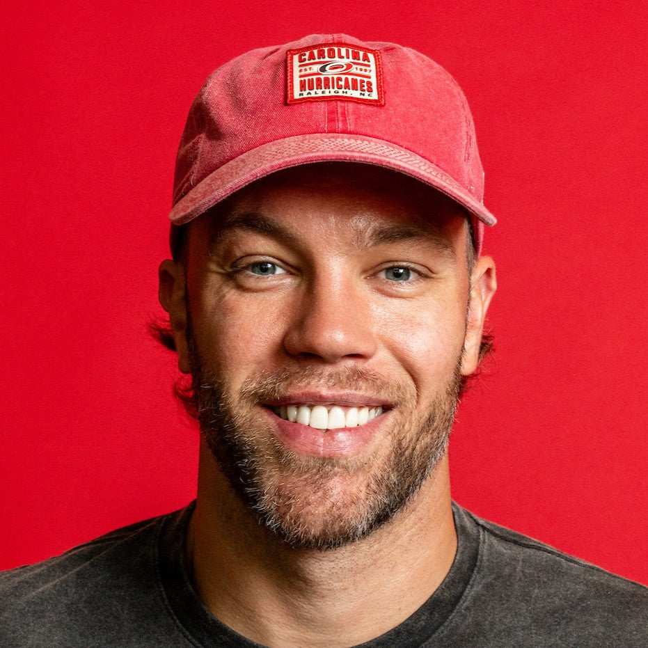 The hat being worn by Hurricanes forward Taylor Hall in front of a red background