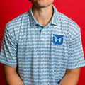 White polo with pattern of blue Sardines; blue Whalers Tail logo on left chest