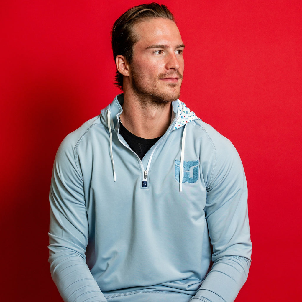 The hoodie being worn by Hurricanes forward Andrei Svechnikov in front of red background