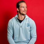 The hoodie being worn by Hurricanes forward Andrei Svechnikov in front of red background