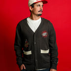 The sweater being worn by Hurricanes forward Seth Jarvis in front of a red background