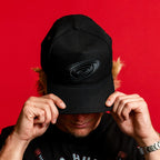 The hat being worn by Hurricanes forward Jackson Blake in front of red background