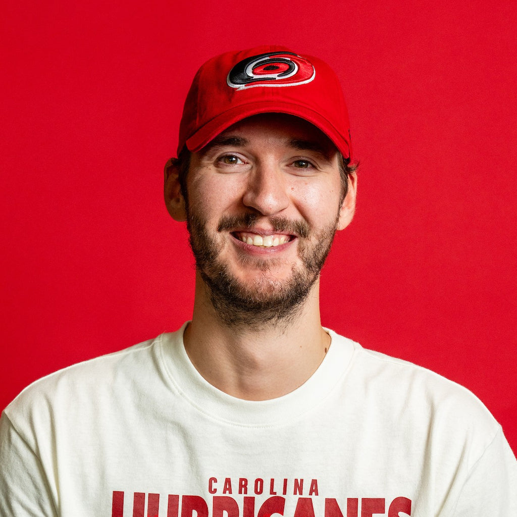The hat being worn by Hurricanes goaltender Brandon Bussi in front of red background