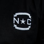 Close up of 'NC' insignia on front of shirt