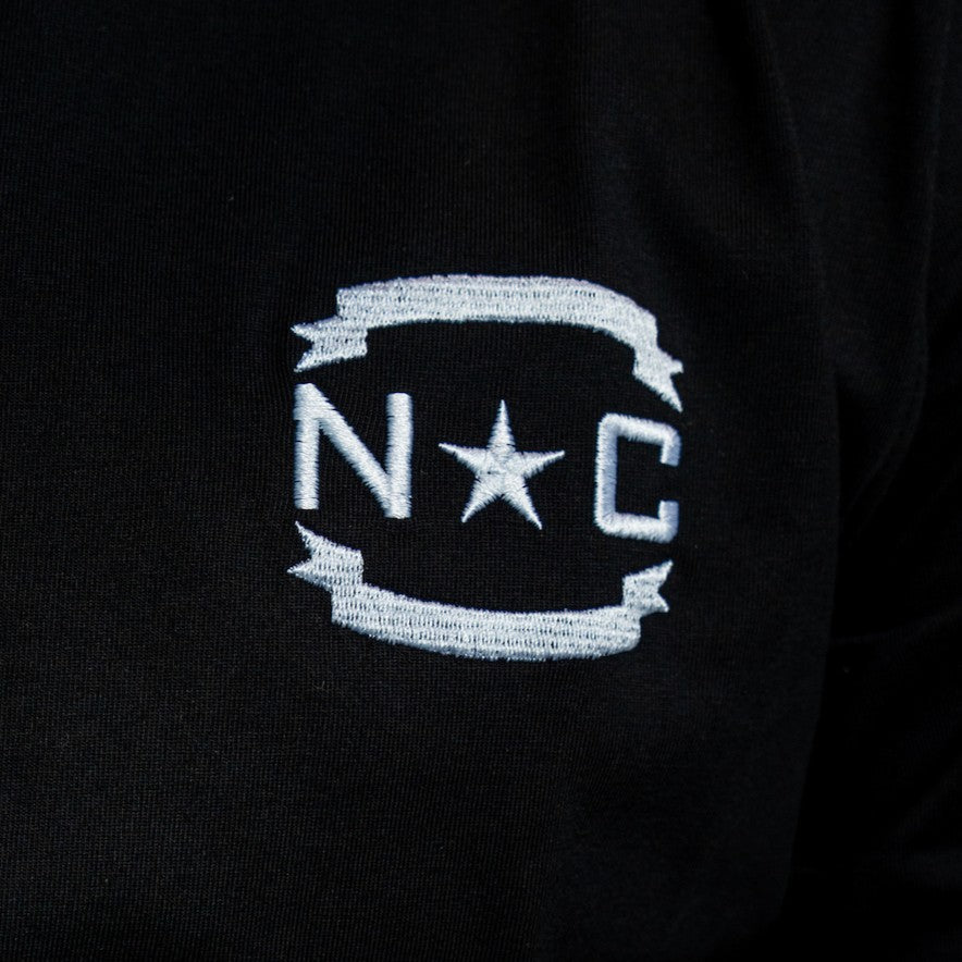 Close up of 'NC' insignia on front of shirt