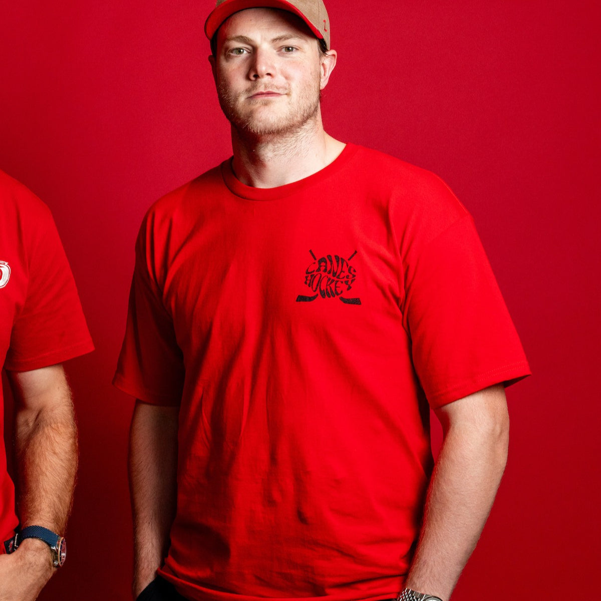 The tee being worn by Hurricanes forward Eric Robinson in front of a red background