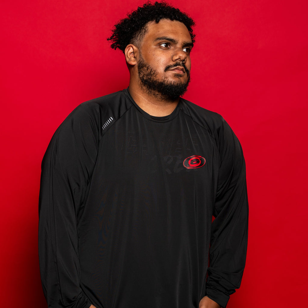 The longsleeve being worn by a model in front of a red background