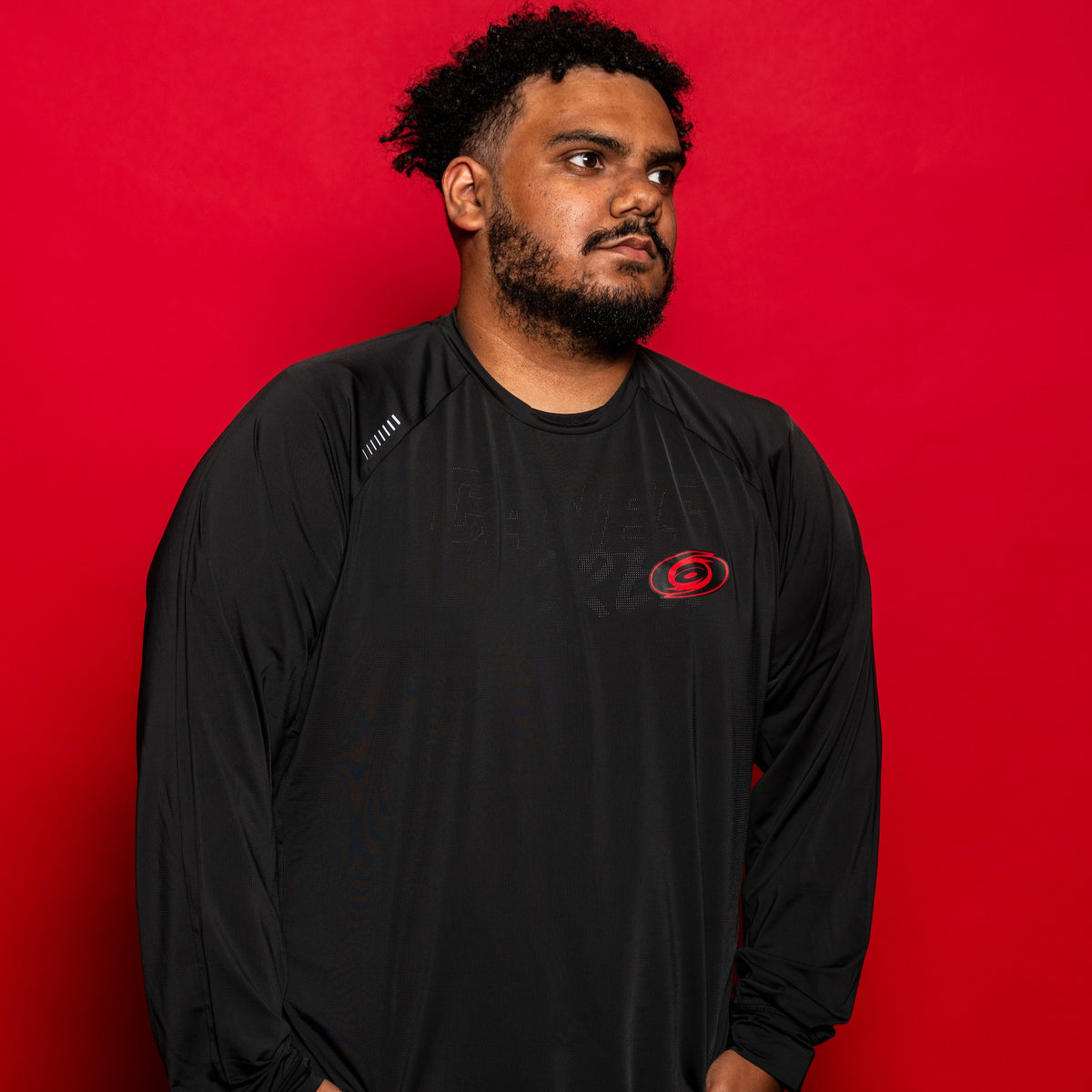 The longsleeve being worn by a model in front of a red background