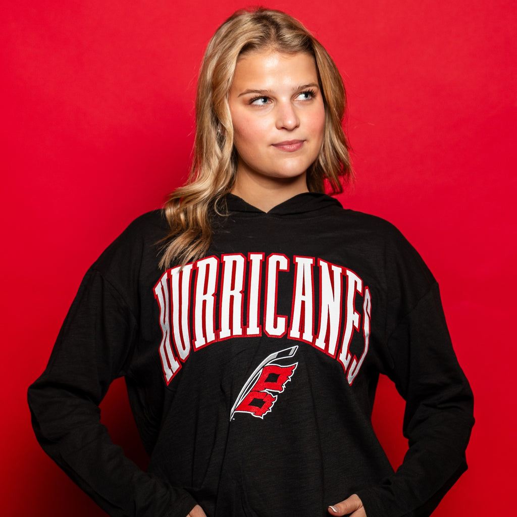 The hoodie worn by a model in front of a red background