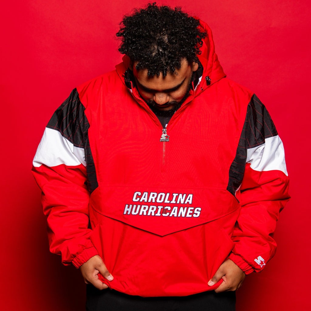 Front: Red half-zip jacket with black/white trim, "CAROLINA HURRICANES" wordmark on white on front pocket