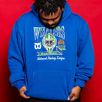 The hoodie being worn by a model in front of a red background