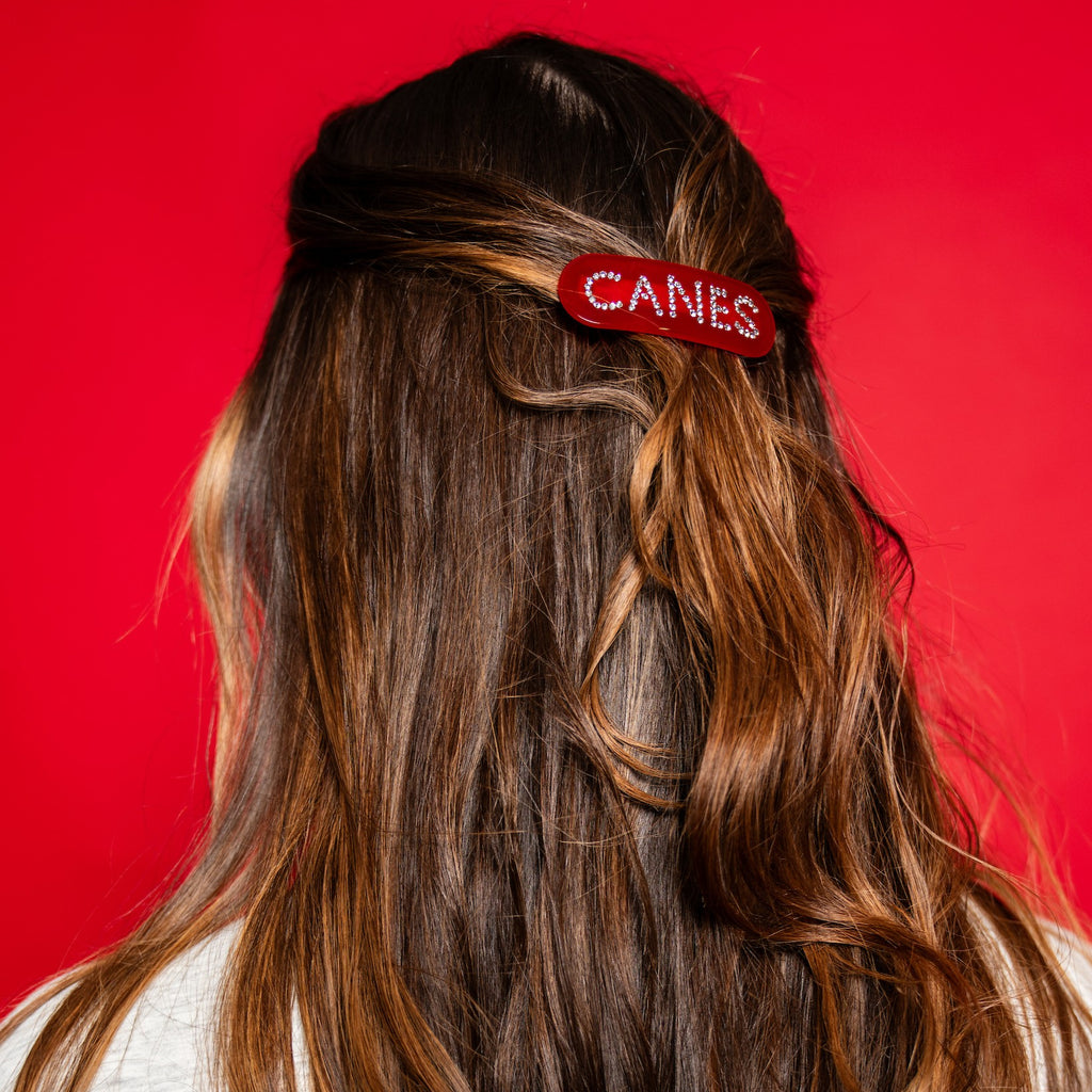 The hair clip being worn by a model in front of a red background