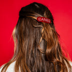 The hair clip being worn by a model in front of a red background