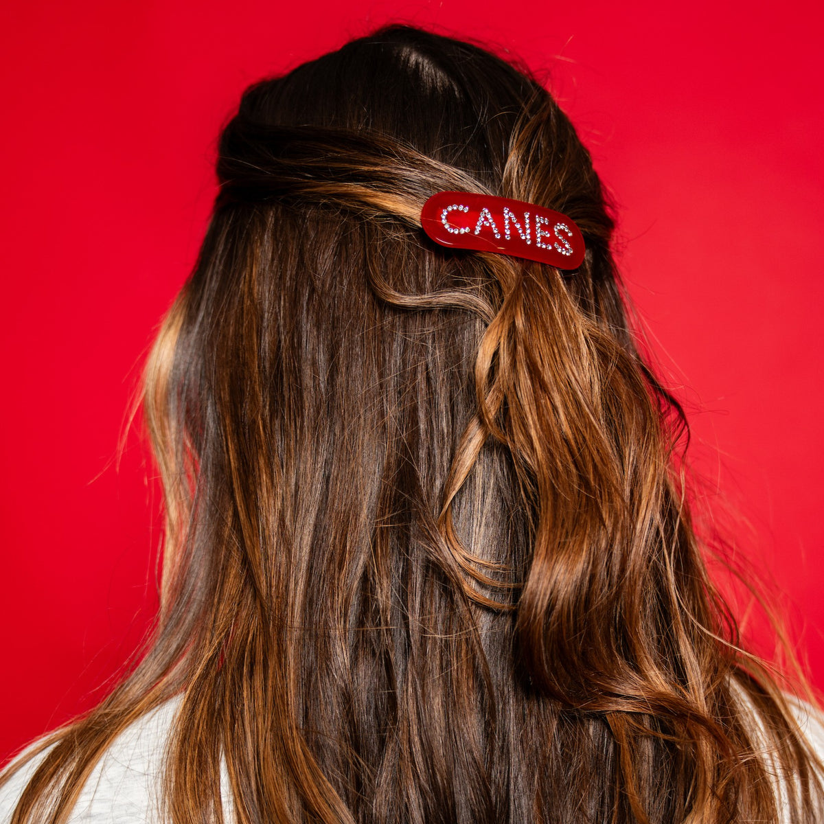 The hair clip being worn by a model in front of a red background