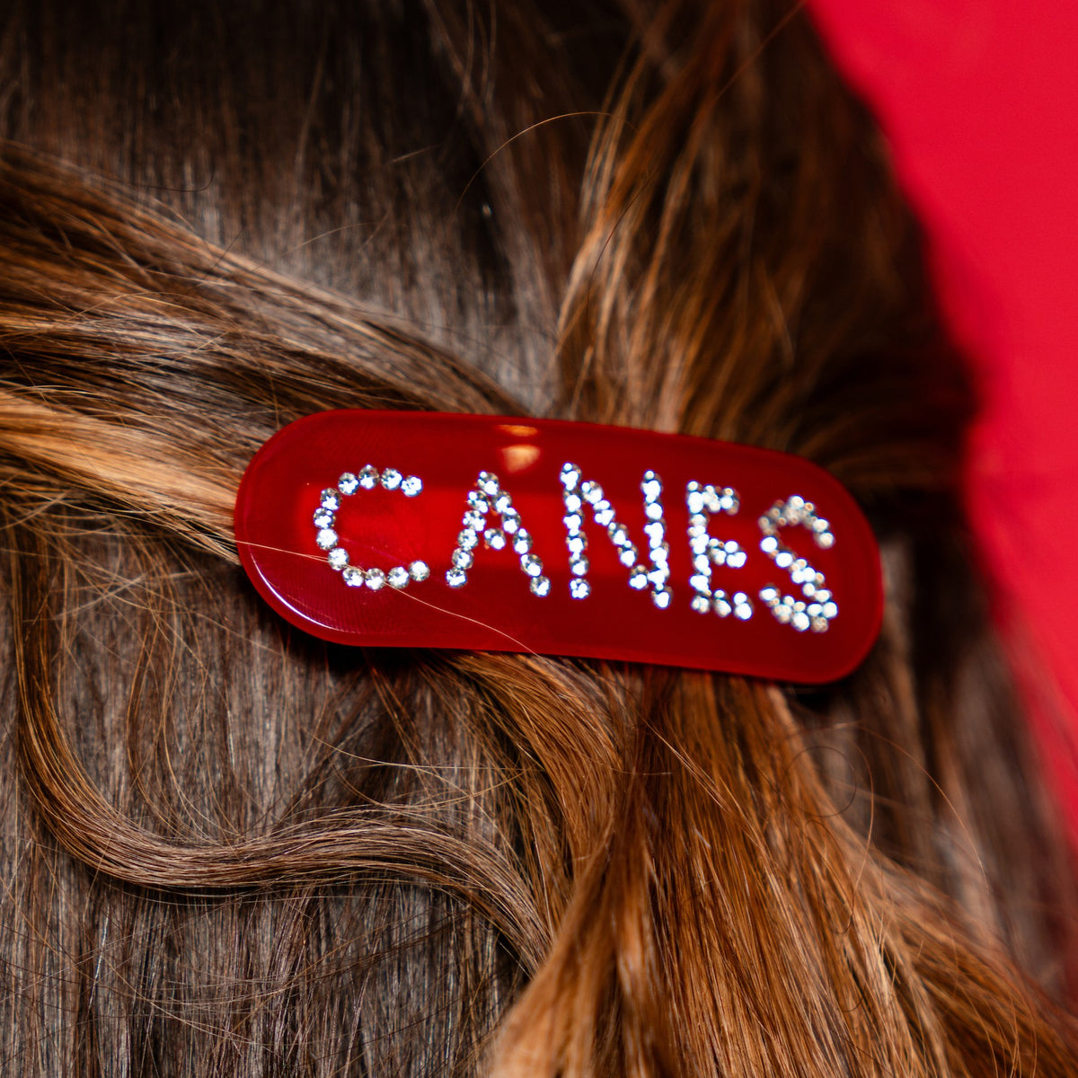 Red hairclip, "CANES" spelled out in small studs