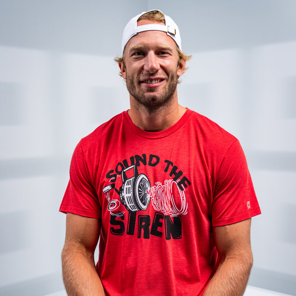Hurricanes Captain and forward Jordan Staal posing smiling with the tee