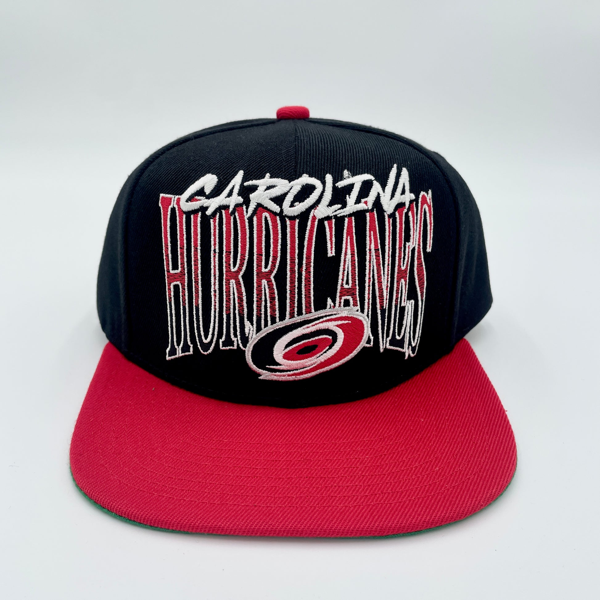 Front: Black hat with red brim, says Carolina in white, Hurricanes in gradient with primary logo