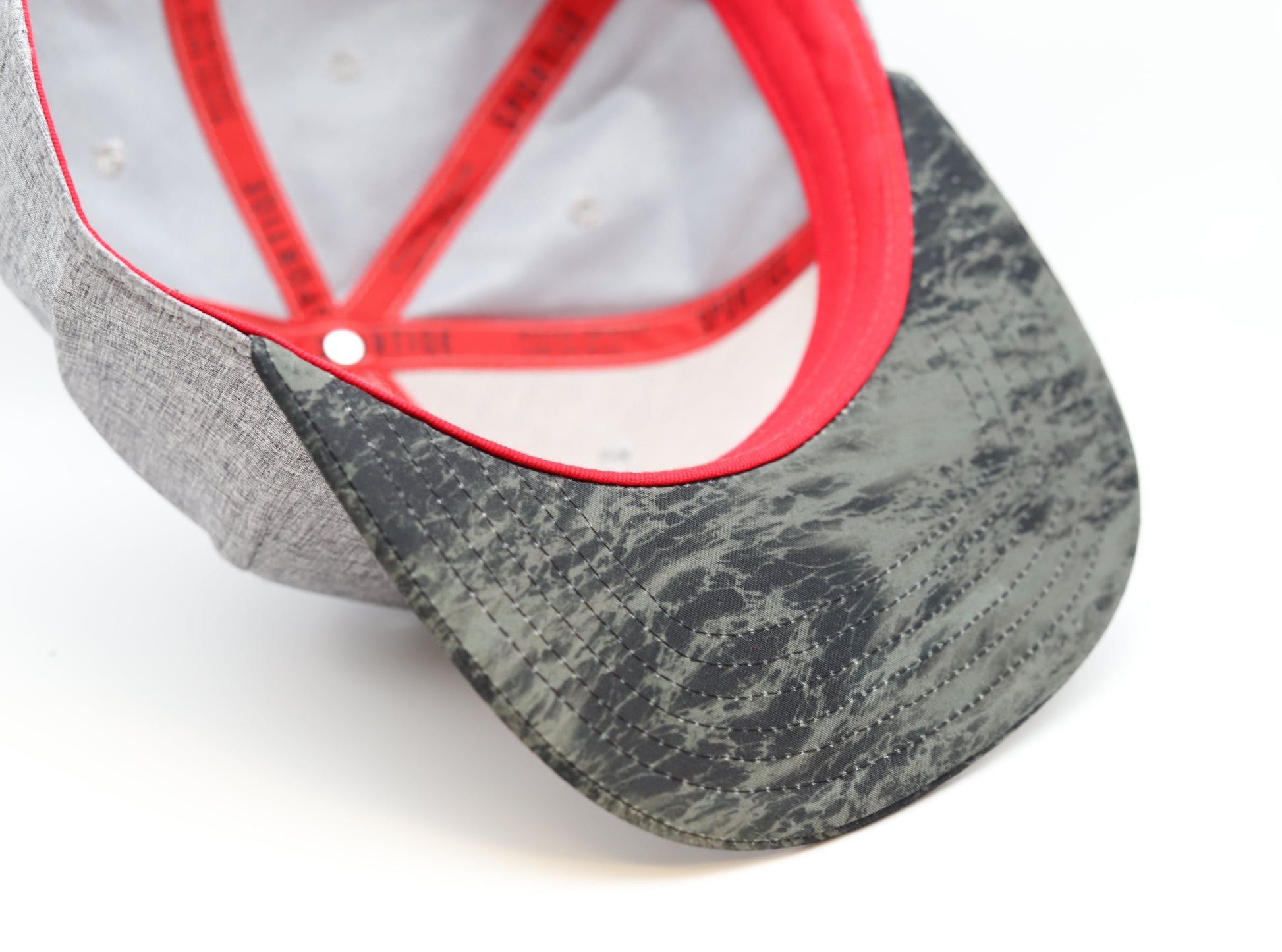 Under: Close up of pattern on brim, white and red interior of hat