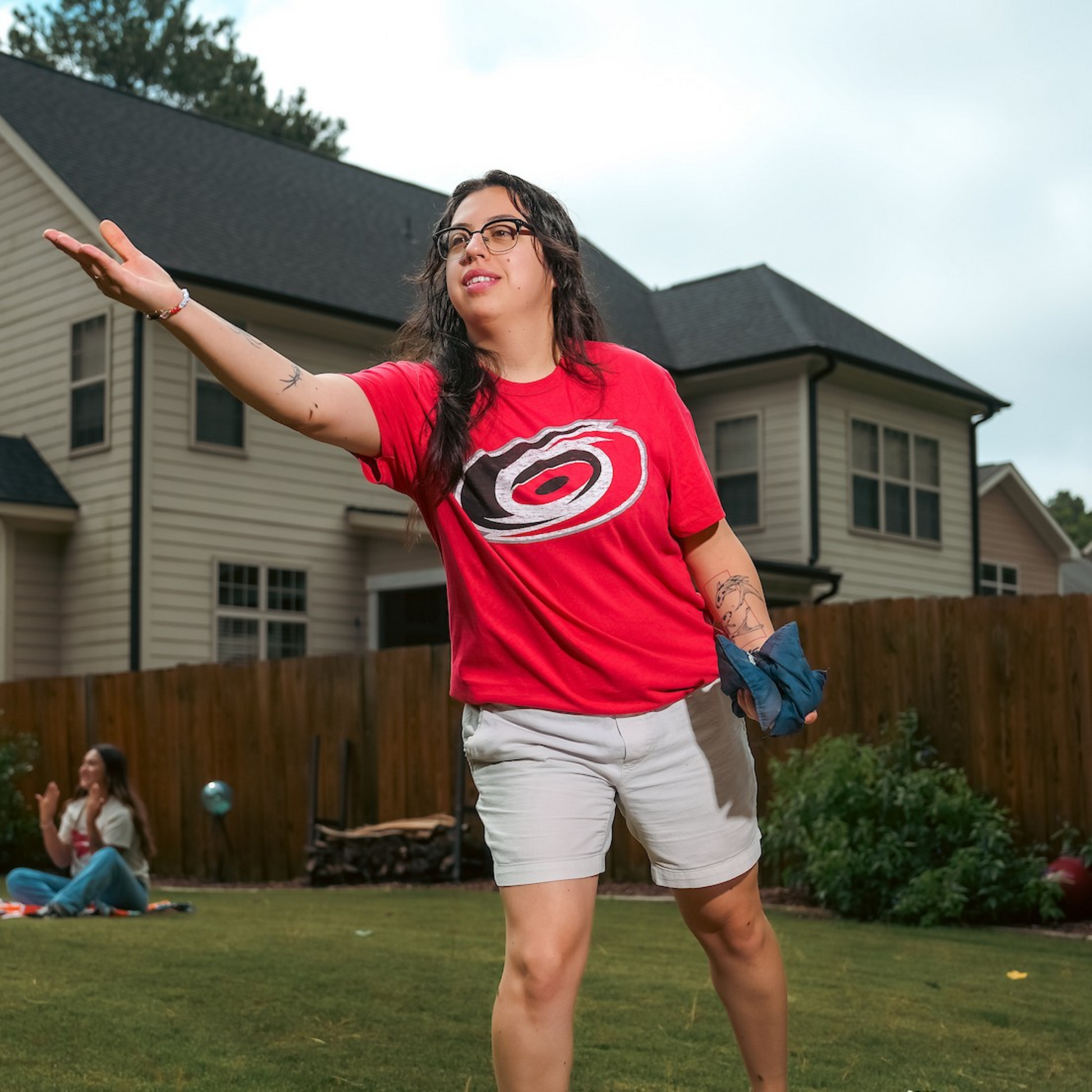 The t-shirt being worn by a model who is playing cornhole