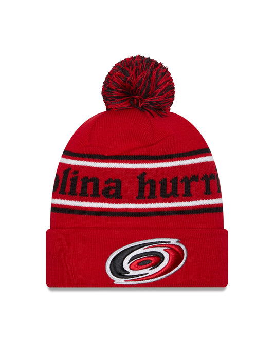 Front: Red cuffed beanie with red and black pom, primary logo on cuff