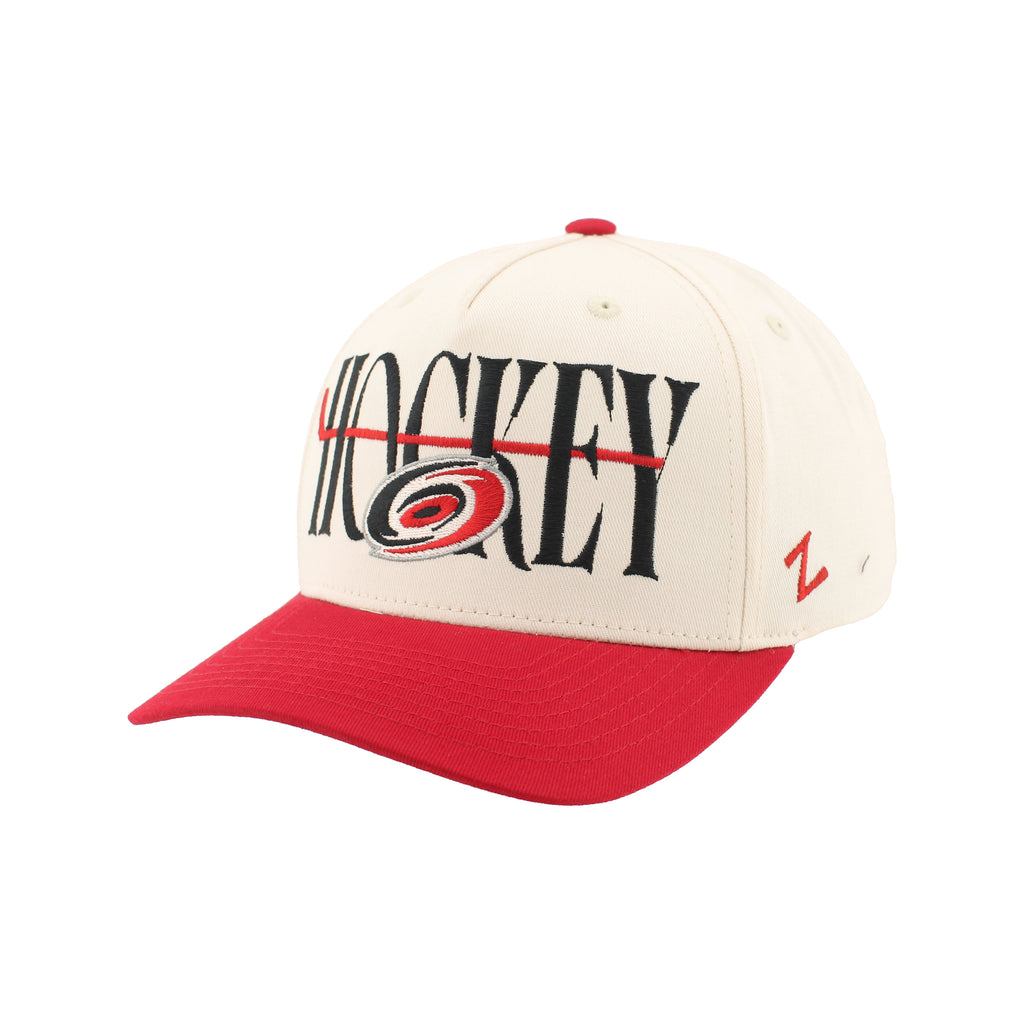Front Left: White hat, red brim, artwork featuring Primary logo, hockey stick on front