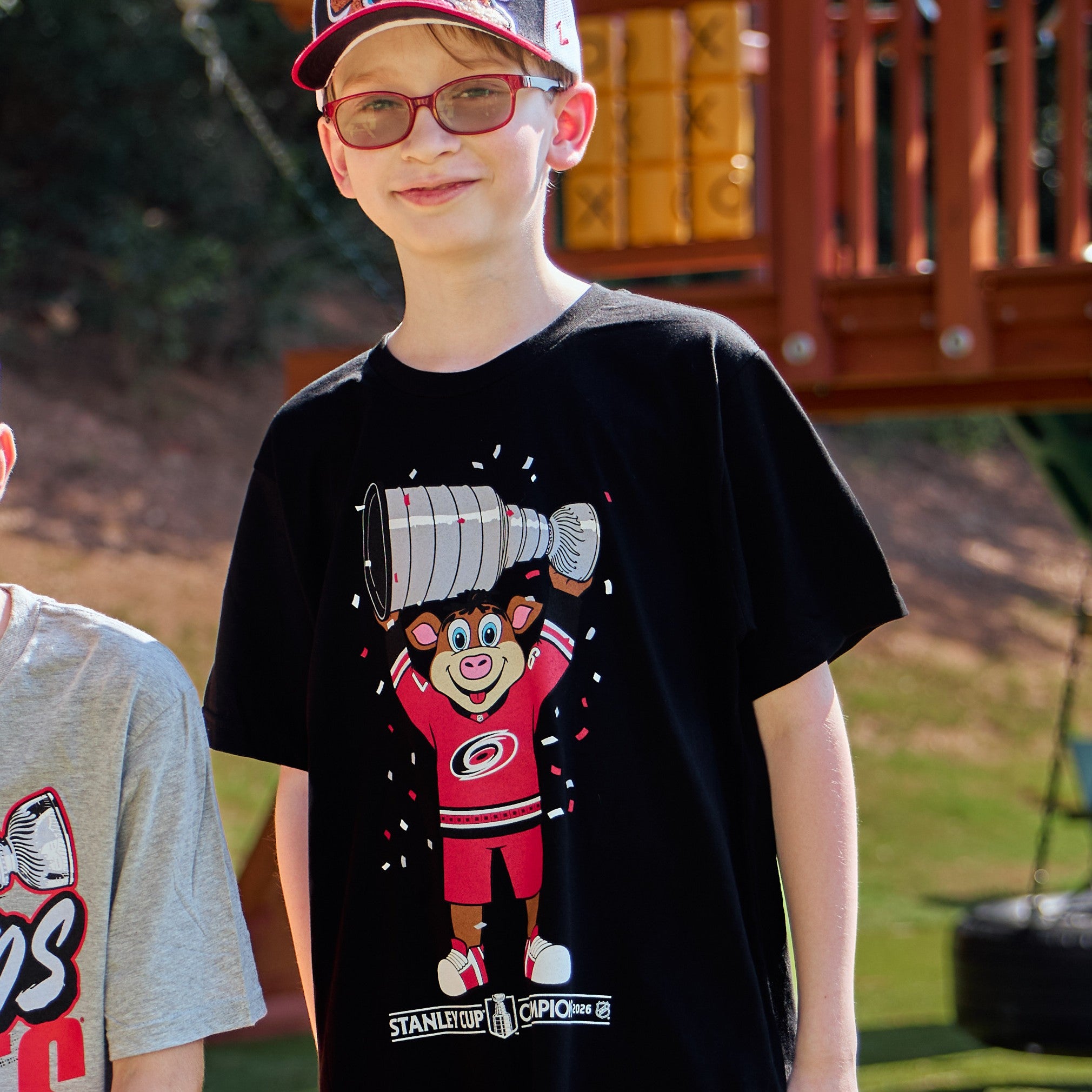 The tee being worn by a model in front of a playground