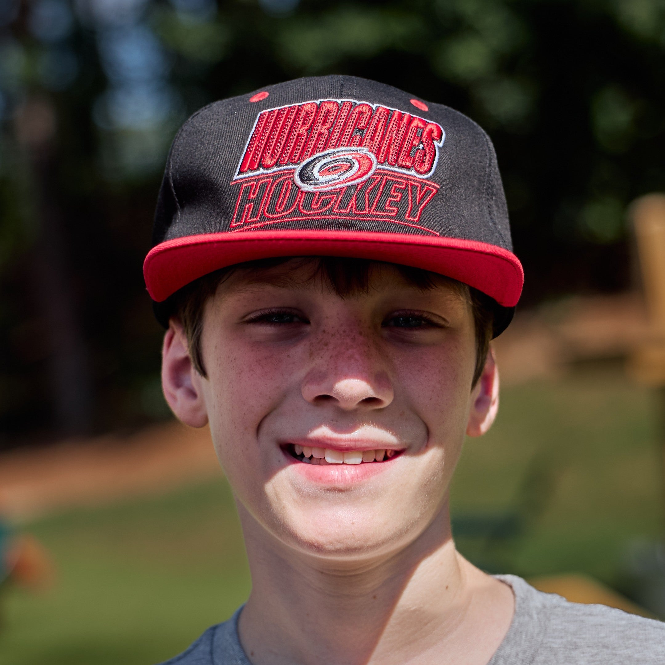 The hat being worn by a model in front of an outdoor background